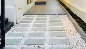 A corridor with a tiled walkway, white walls, and balconies with railings.