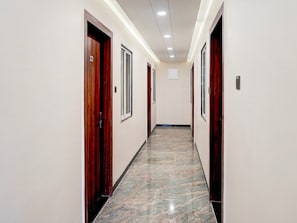 Passadís amb portes de fusta, sòl de marbre i il·luminació encastrada al sostre.
