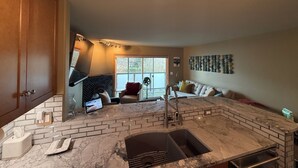 A kitchen with a marble countertop, a sink, and a window with a view. - Modern 1-bedroom condo in West Seattle, with quick access to downtown (Seattle)
