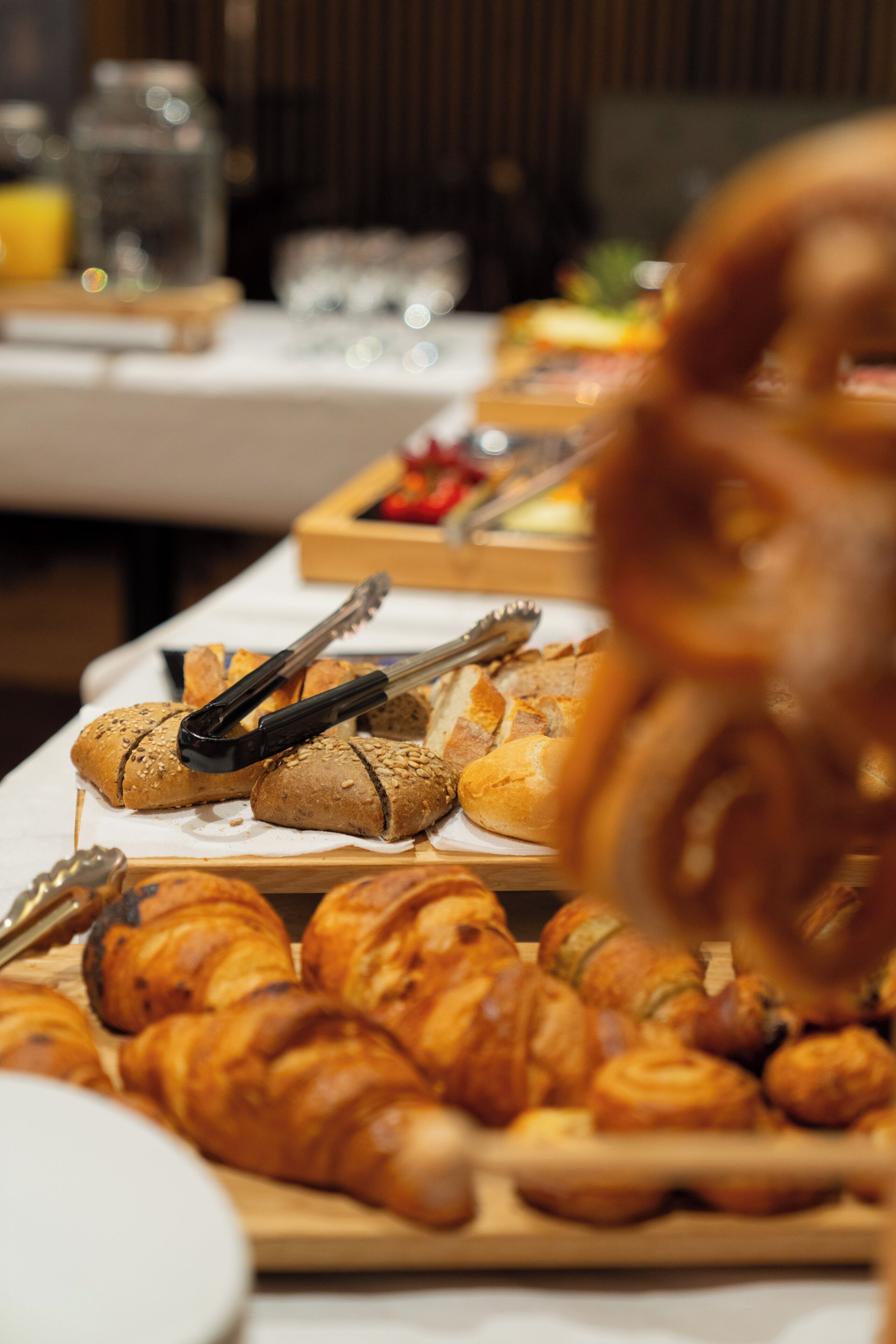 Ein reichhaltiges Buffet mit verschiedenen Backwaren, darunter Croissants und Brötchen.