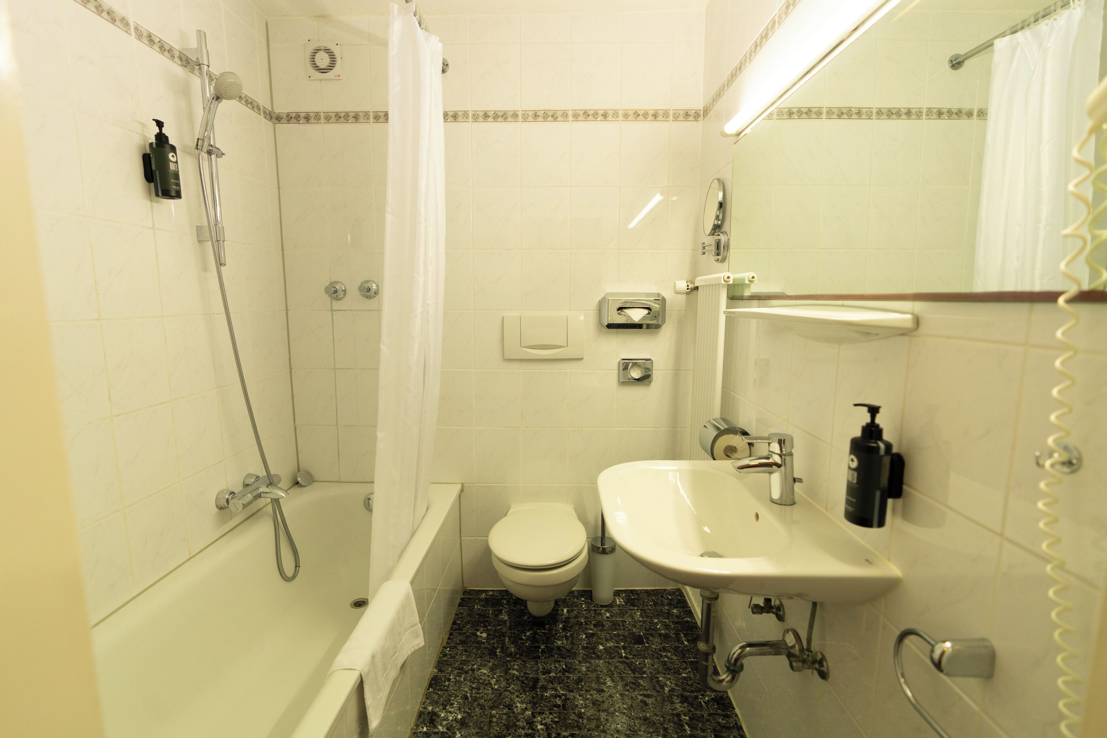 A bathroom with a bathtub, toilet, and sink.