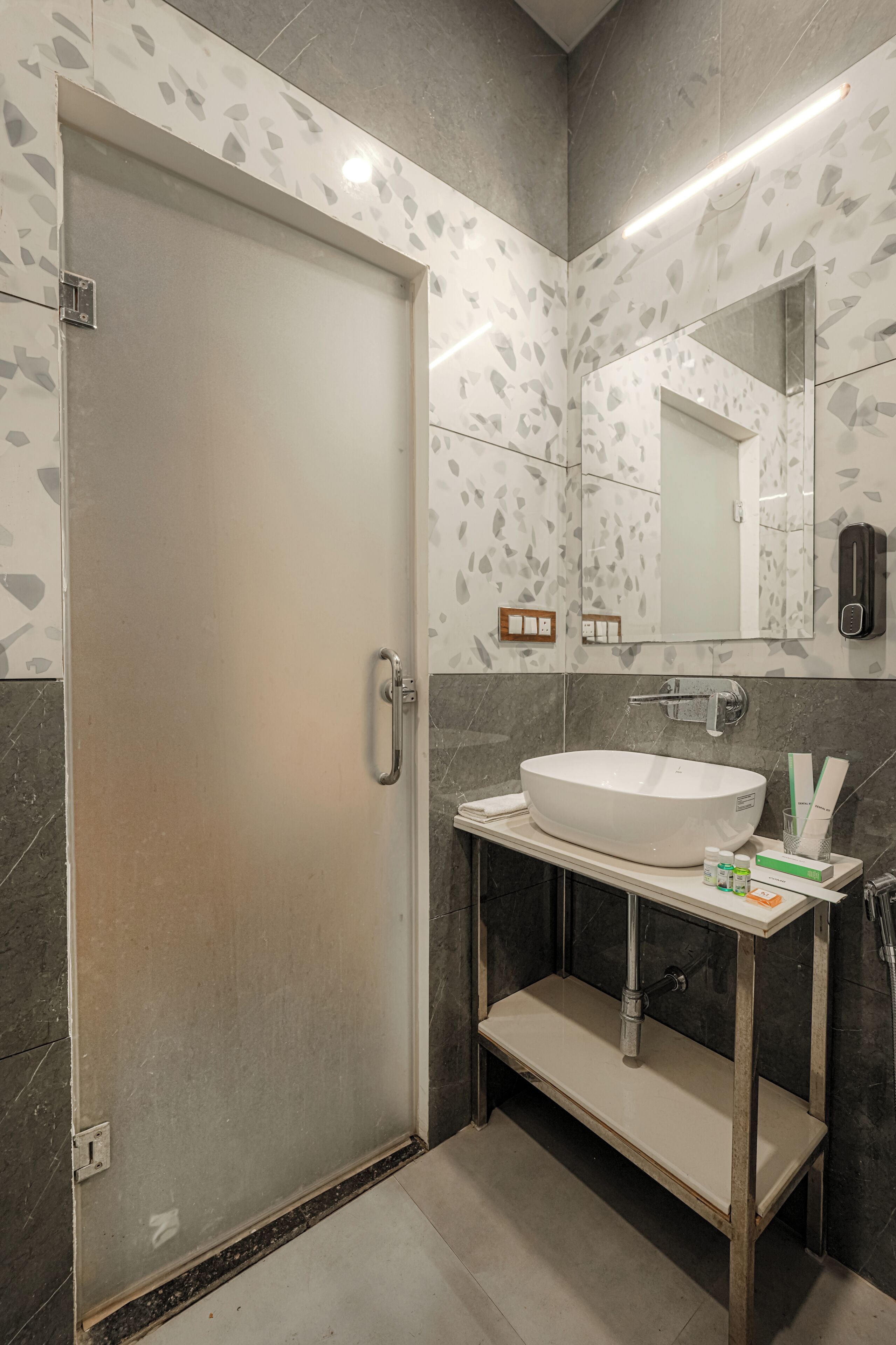A bathroom with a white sink, a mirror, a towel rack, and a door.