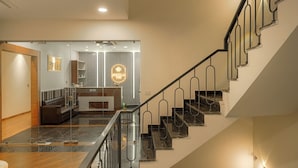 Un interior moderno con una escalera, una zona de recepción y un área de descanso.
