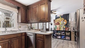 A kitchen with wooden cabinets, a dishwasher, and a refrigerator. - Exceptional location with both Weekapaug Beaches and Quonnie Salt Pond Access (Charlestown)
