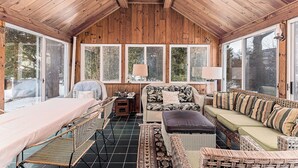 A wooden-paneled room with a bed, a sofa, a chair, and a table. - Exceptional location with both Weekapaug Beaches and Quonnie Salt Pond Access (Charlestown)