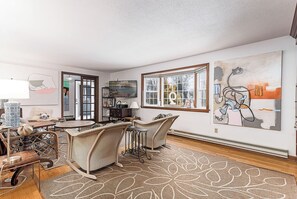 A room with a dining table, two chairs, a rug, a bookshelf, and artwork on the walls. - Exceptional location with both Weekapaug Beaches and Quonnie Salt Pond Access (Charlestown)