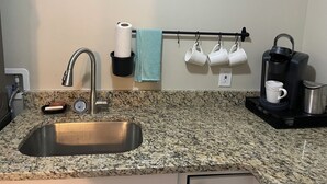 A kitchen with a granite countertop, a stainless steel sink, a coffee maker, and a towel rack with cups. - FIFA FANS STAY HERE! Excellent location minutes from Atlanta Airport and STADIUM (atlanta)