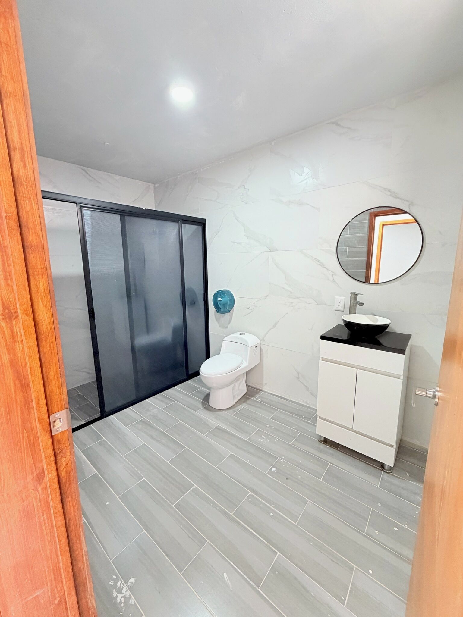 Une salle de bain avec des toilettes, un lavabo et un miroir.