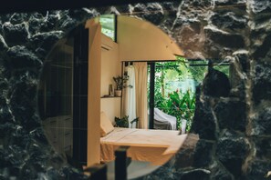 A room with a bed, a window, and a view of greenery outside. - Stunning 2BR Home with Fast WiFi & AC – Mountain Views & Lush Nature, Ojochal (Puntarenas Province)