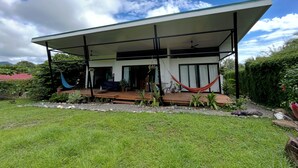 A modern house with a covered patio, a hammock, and a garden. - Stunning 2BR Home with Fast WiFi & AC – Mountain Views & Lush Nature, Ojochal (Puntarenas Province)