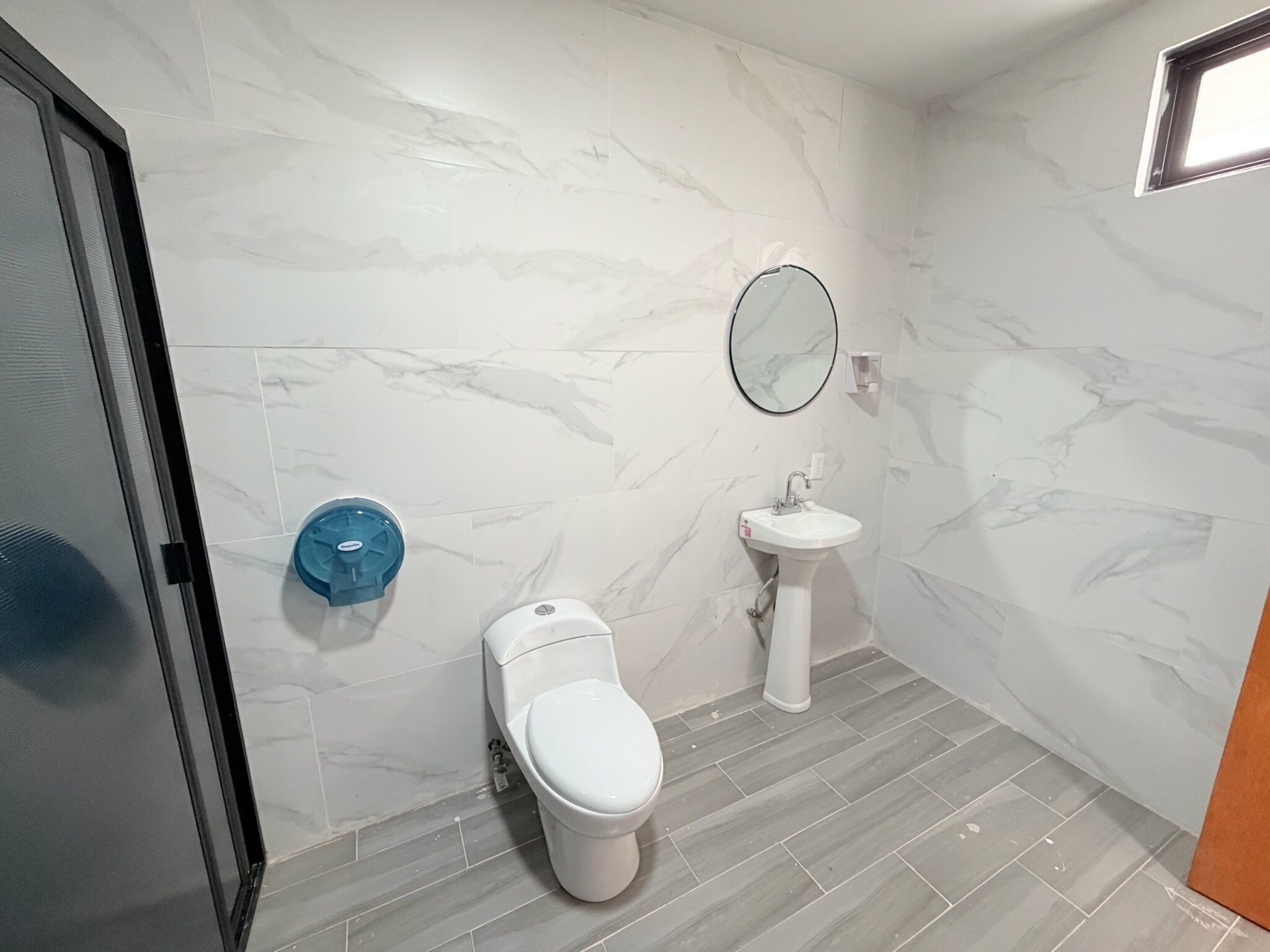 A bathroom with a toilet, sink, and blue soap dish.