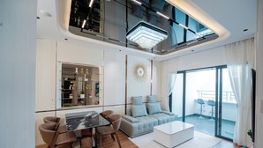 Un salon moderne comprenant un coin repas, un canapé, une table basse et un balcon avec deux chaises.