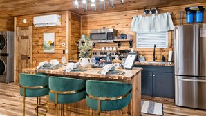 Een houten chalet van binnen met een keuken, een bar en zitplaatsen.