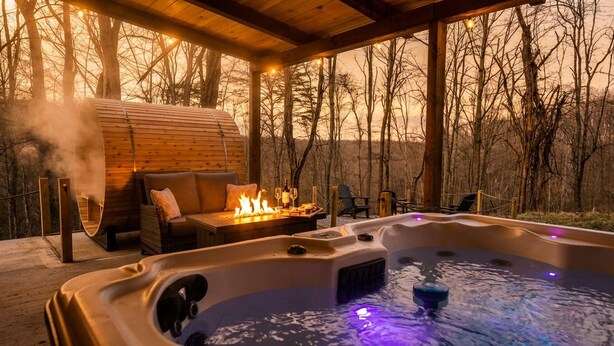 Een houten chalet met een hottub, vuurkorf en een bank.