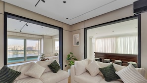 Un salon moderne avec deux canapés beige, une table basse et un grand miroir qui reflète la pièce.