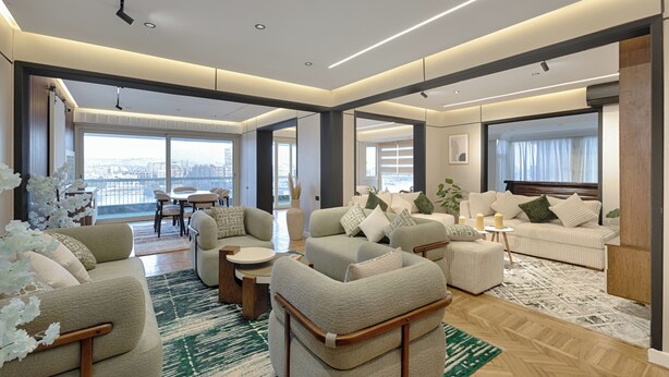 Un salon moderne comprenant un ensemble de canapés, une table basse et un coin repas avec des chaises.