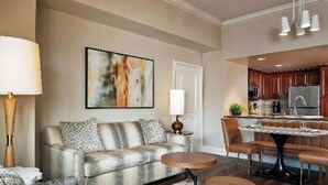 Un salon comprenant un canapé, une table basse ronde et un coin repas avec une table et des chaises.