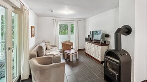Una sala de estar con sofá, sillón, mesa de centro y chimenea.