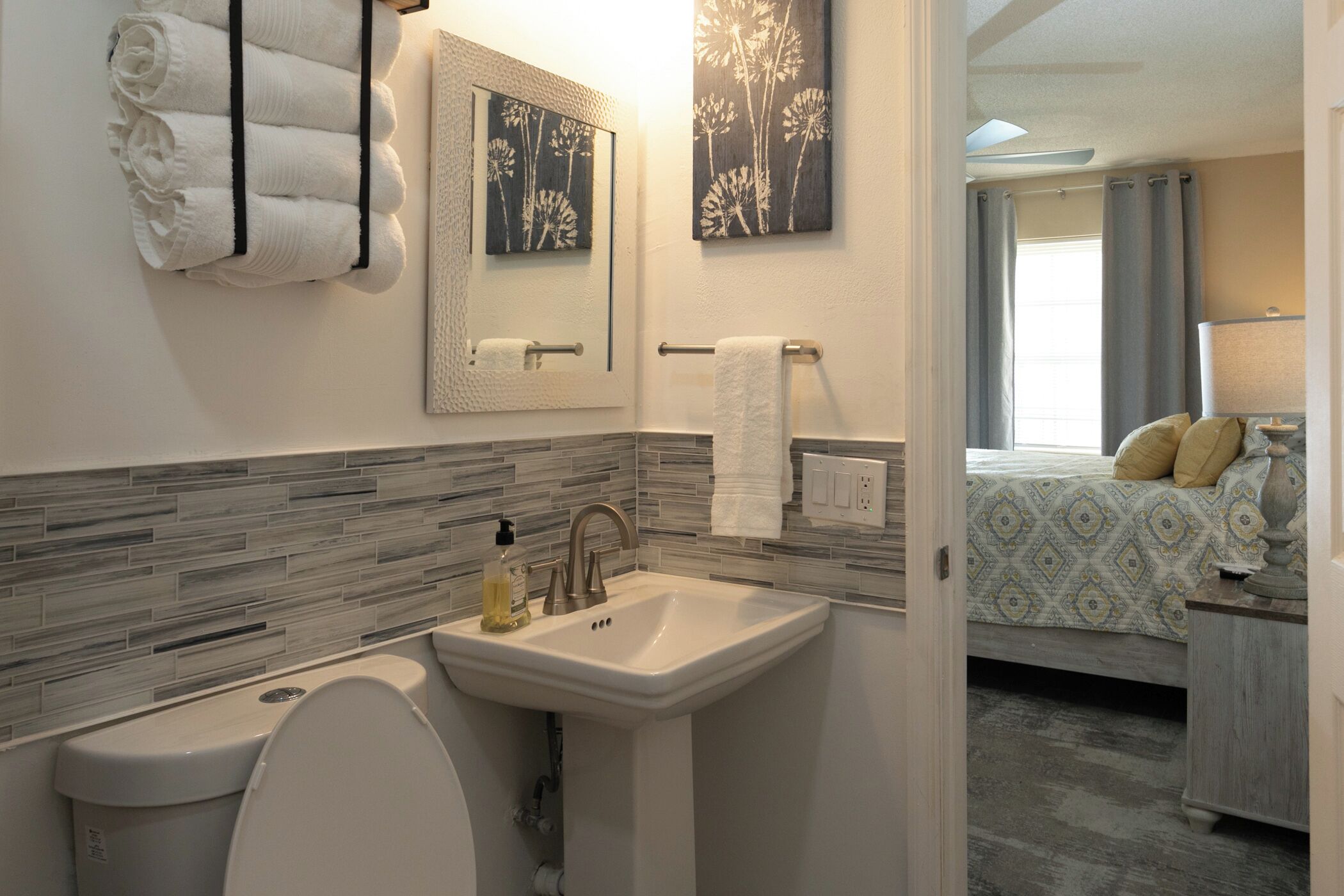 A bathroom with a toilet, sink, and towel rack.