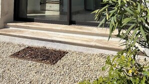 Un edificio moderno con facciata in pietra, ampie vetrate e una scala ben visibile che conduce all'interno.
