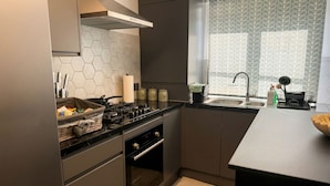Une cuisine moderne équipée d’une cuisinière à gaz, d’un four encastré, d’un évier en acier inoxydable et d’une fenêtre offrant une vue intéressante.