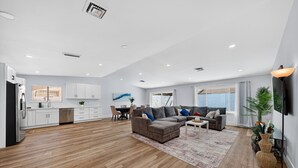 A modern living space with a kitchen, dining area, and seating area.