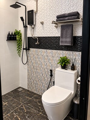 A modern bathroom with a shower, toilet, and a towel rack. - 1-bedroom ,
own bathroom and shared kitchen in adorable Kata Phuket with AC (Muaeng Phuket)