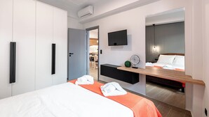 Ein modernes Hotelzimmer mit Bett, Fernseher, Schreibtisch und Spiegel.