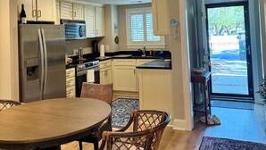 Une cuisine moderne équipée d’un réfrigérateur, d’une cuisinière et d’un coin repas avec des chaises et une table.