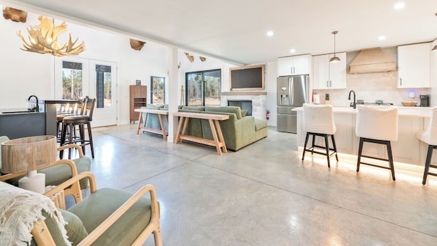 A modern kitchen with a dining area, a sofa, and a bar area. - 3-bedroom barn in gorgeous Folkston with AC for relaxing stays (Folkston)