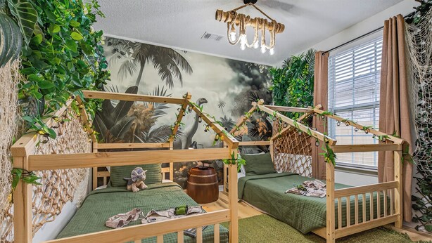 Ein Zimmer mit einem Etagenbett, Wandgemälde und einer Wand mit Netzvorhängen.