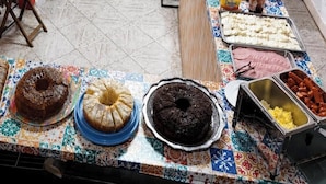 A buffet table with various baked goods and deli items. - Pousada Ilha do Itacolomi (Penha)