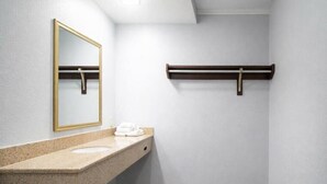 A bathroom with a granite countertop, a mirror, a towel rack, and a wooden floor. - Comfort Room, One king Bed, Non-smoking (Nashville)