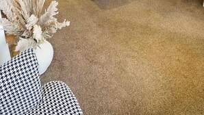 Una sala de estar con un aparador de madera, sofá blanco y una mesa de centro de vidrio.