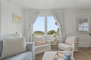 A room with a sofa, two armchairs, a small table, and a window with curtains. - Spacious Group Getaway w/ Main House + Private Studio, Sleeps 10, Ideal for Families (Rockaway Beach)