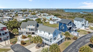 A residential area with houses, a road, and a body of water in the background. - Golden Hour Getaway | Sleeps 12 | Pool + Beach (Atlantic Beach)