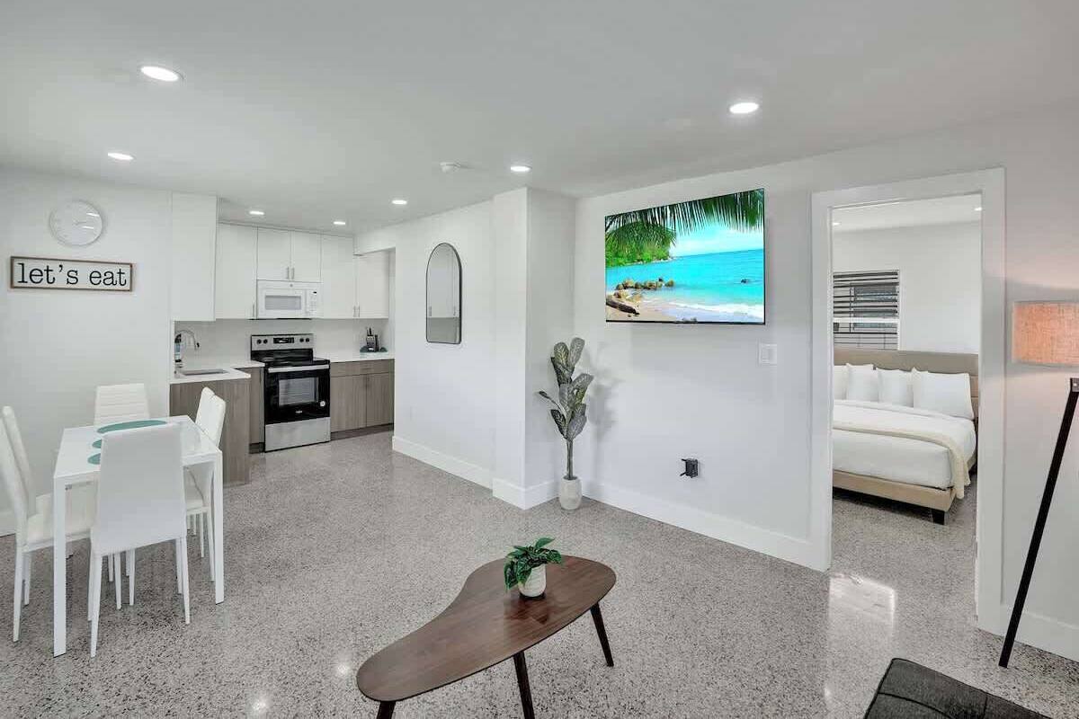 A modern apartment with a kitchen, dining area, and a bedroom.