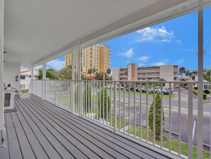 Un balcón con vista a un estacionamiento y edificios.