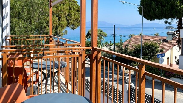 A balcony with a view of the sea, a table, chairs, and a railing. - My Sunset Suite Apartments (Kuşadası)
