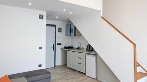 A modern apartment with a kitchen, a staircase, and a living area. - My Sunset Suite Apartments (Kuşadası)