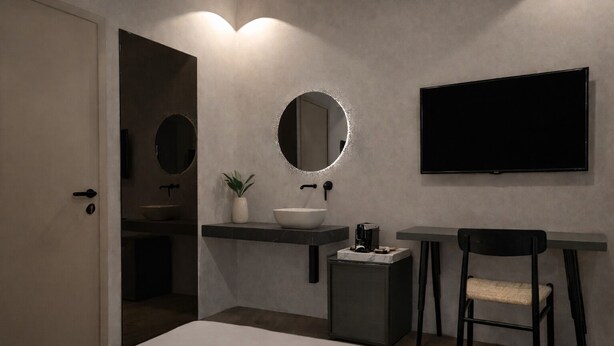 A modern bathroom with a sink, mirror, and a flat-screen TV mounted on the wall. - CAVO III Luxury Rooms (Chania)