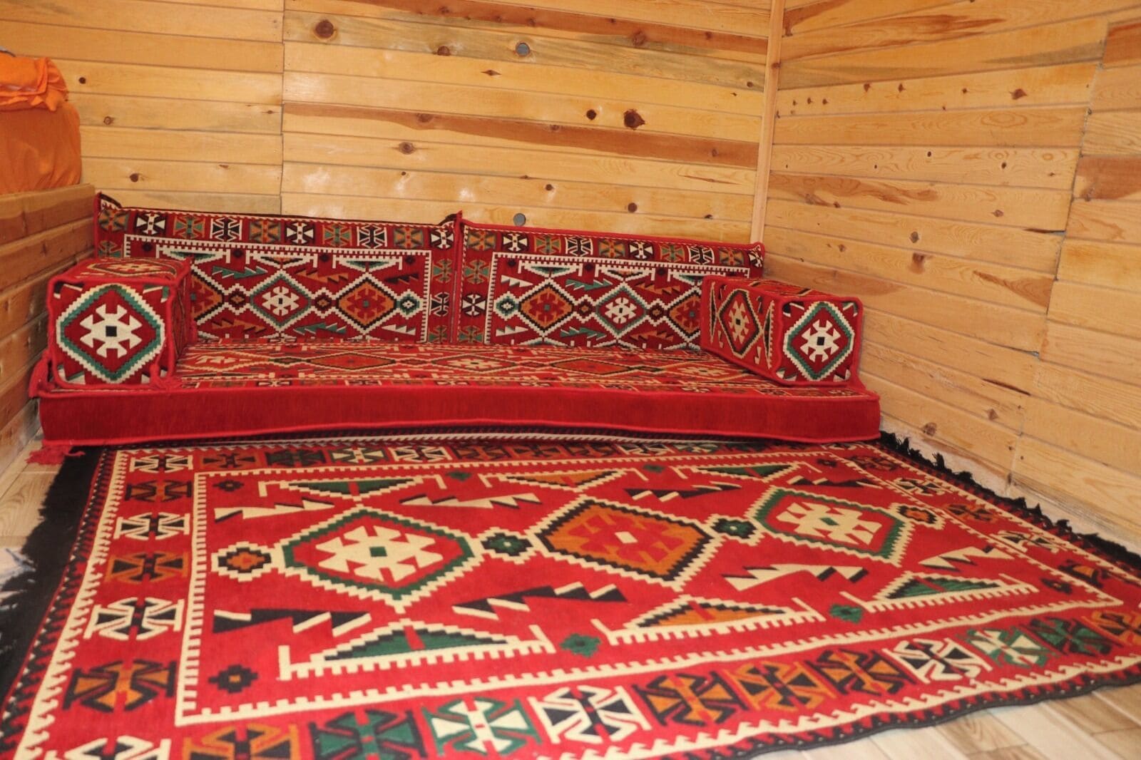 Ein Holzinterieur mit einer Couch und einem gemusterten Teppich.