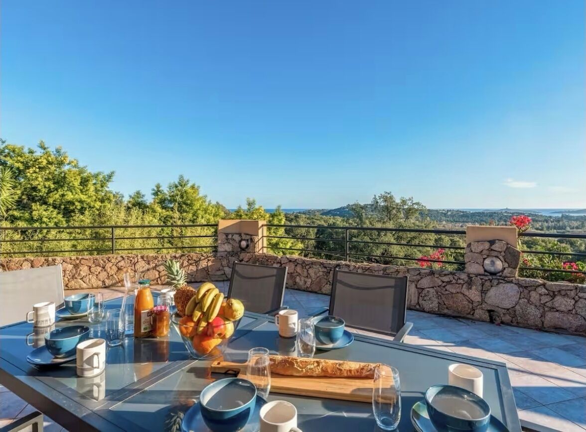 A dining table set outdoors with a clear view of the landscape.
