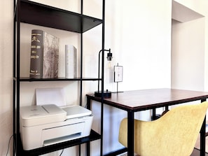A workspace with a desk, chair, bookshelf, printer, and a wall-mounted lamp. - YR Apartment -Glass fiber - Printer - Close to the city center (Chemnitz)