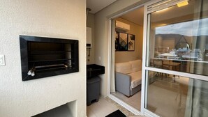 Un apartamento moderno con chimenea integrada, puerta corrediza al balcón y un pequeño cubo de basura.