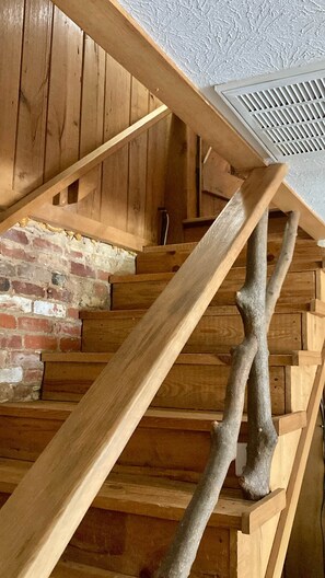 A wooden staircase with a brick wall at the bottom. - Private 1940s Barn • Private Lake • Firepit (Saluda)