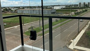 A balcony with a view of a road, buildings, and a cloudy sky. - Hotel Blox Sorriso (Sorriso)
