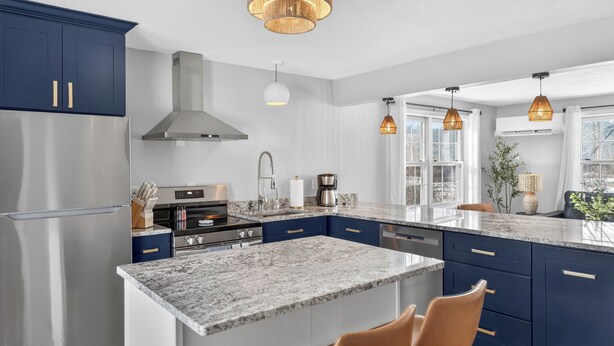 A modern kitchen with a central island, stainless steel appliances, and pendant lighting. - Amherst -NEW - Campus Convenience & Social Privacy (Amherst)