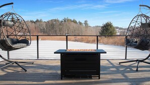A deck with two hanging chairs and a table, overlooking a snowy landscape. - Amherst -NEW - Campus Convenience & Social Privacy (Amherst)