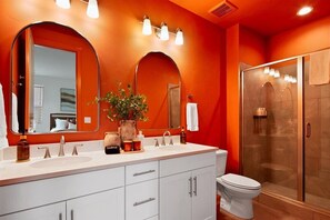 A bathroom with a double sink vanity, a toilet, a glass-enclosed shower, and a large mirror. - The Haven, Desert Inspired Retreat in Star | Zippy Wi-Fi, Sleeps 8 (Star)